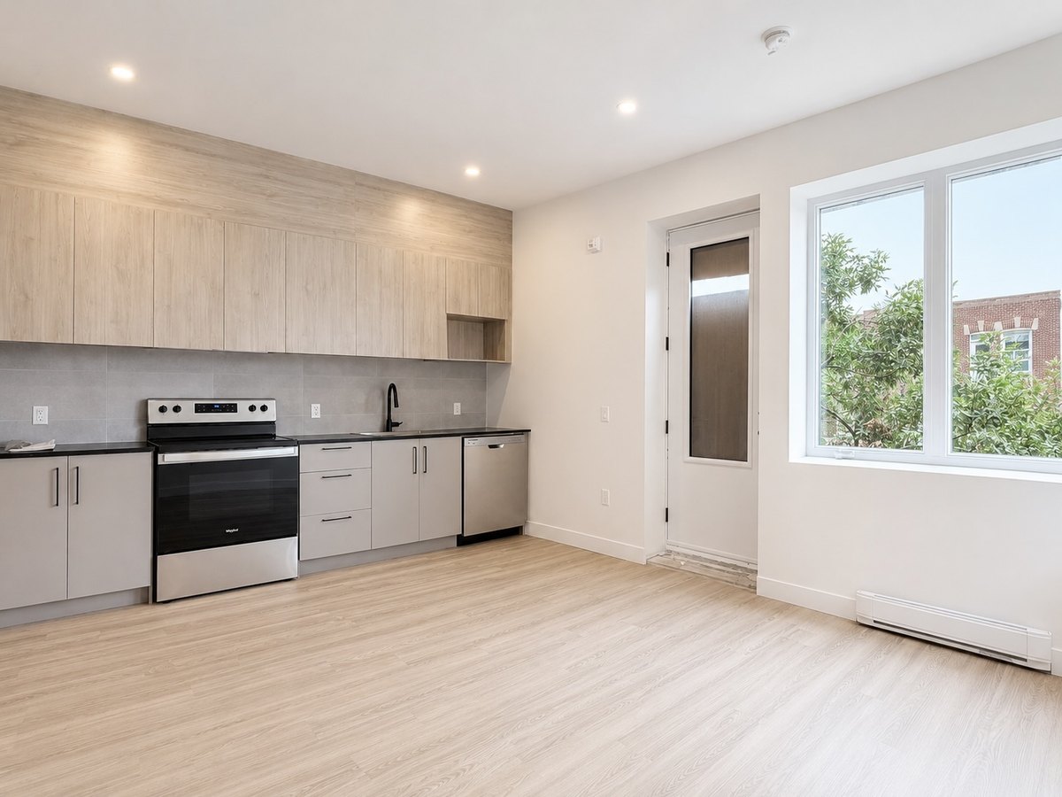 Rosemont : cuisine ouverte avec armoires au fini bois clair et grande fenêtre.